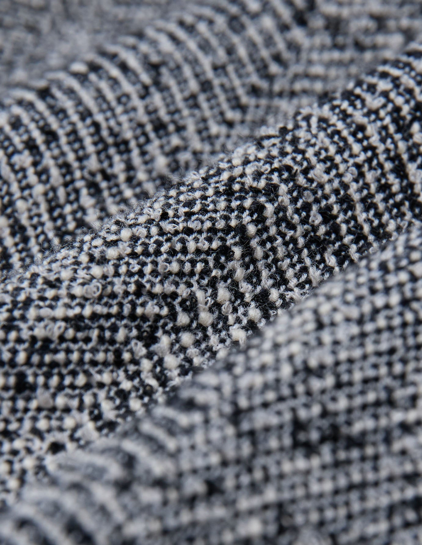 Nahaufnahme des strukturierten schwarz-weißen Fischgräten-Bouclé-Stoffs der Damenhose Ashryn Pants Wide Domino Herringbone.